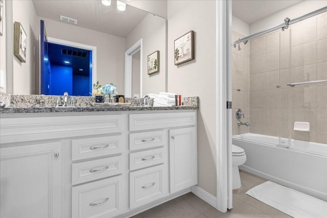 full bathroom featuring tile patterned flooring, toilet, vanity, and tiled shower / bath