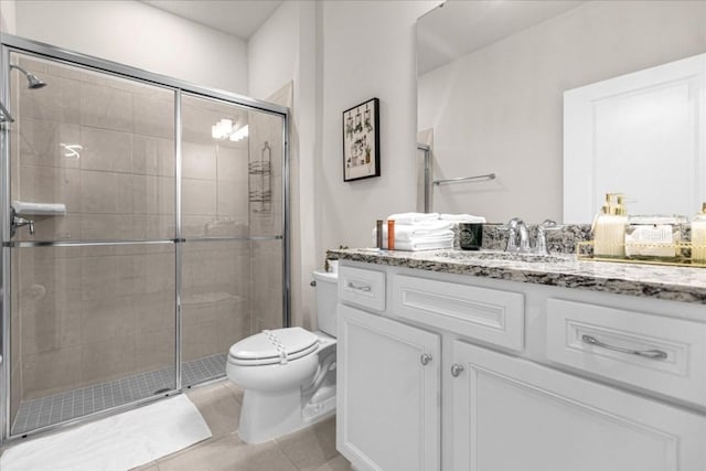 full bathroom featuring toilet, a stall shower, vanity, and tile patterned floors