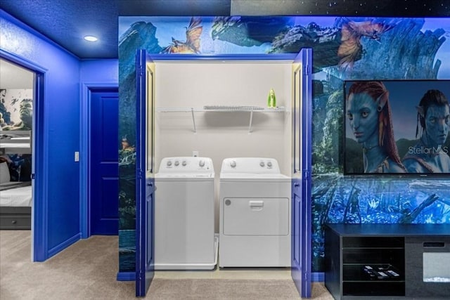 clothes washing area with washing machine and clothes dryer and light colored carpet