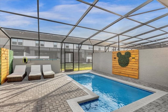 view of swimming pool featuring a patio area and a lanai