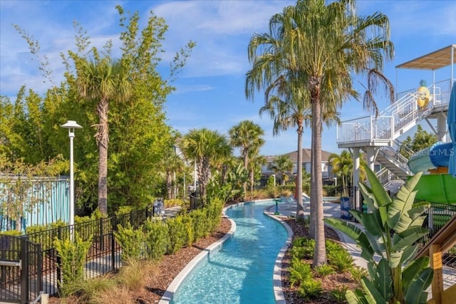 view of property's community featuring a pool and fence