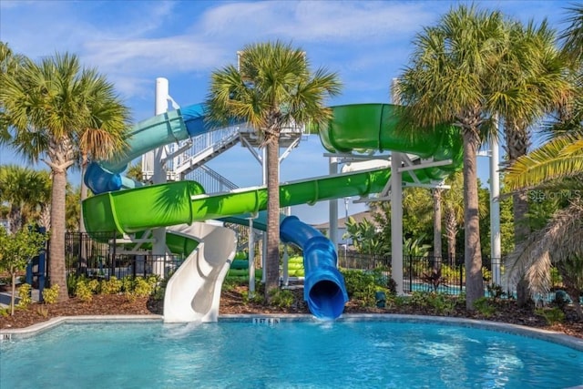 view of pool with playground community and fence