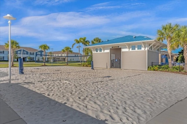 view of property's community with volleyball court, fence, and a residential view