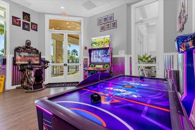 playroom featuring french doors, hardwood / wood-style floors, and a paneled ceiling