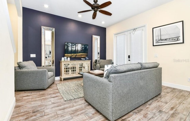 living room with ceiling fan and light hardwood / wood-style flooring