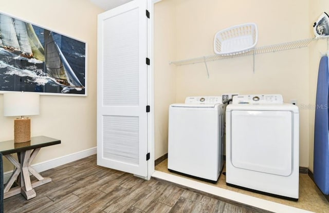 laundry room featuring washing machine and clothes dryer and hardwood / wood-style flooring