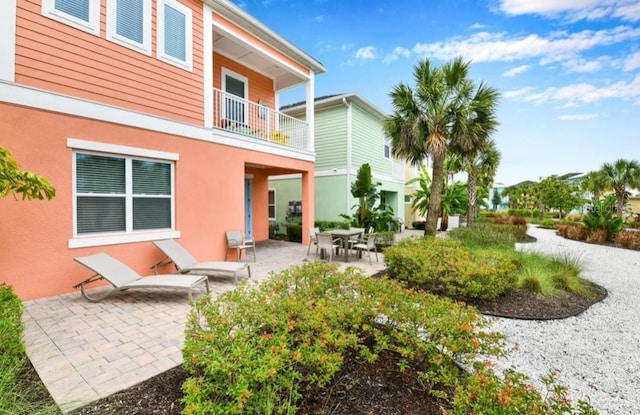 back of property featuring a patio and a balcony