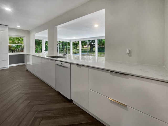 kitchen featuring white cabinets, dishwasher, sink, and dark parquet floors