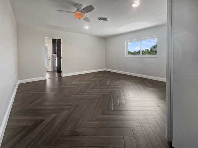 empty room featuring ceiling fan and dark parquet flooring