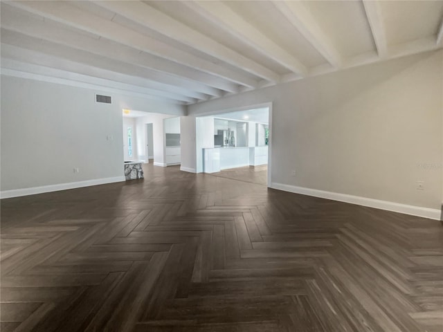 spare room featuring beamed ceiling and dark parquet flooring