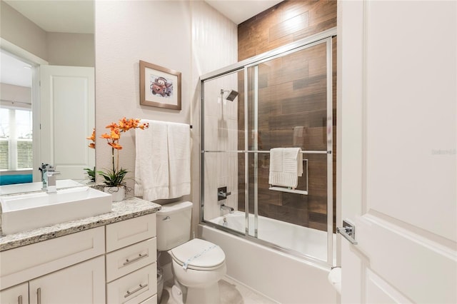 full bathroom with vanity, bath / shower combo with glass door, and toilet