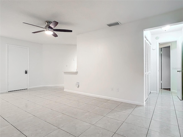 empty room featuring ceiling fan and light tile patterned floors