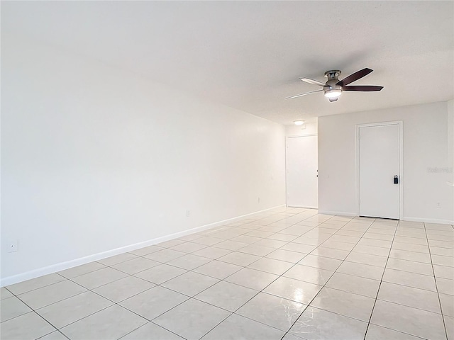 tiled empty room with ceiling fan and a textured ceiling