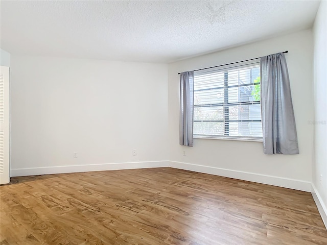 empty room with hardwood / wood-style flooring and a textured ceiling