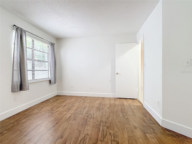 spare room with wood-type flooring and a textured ceiling