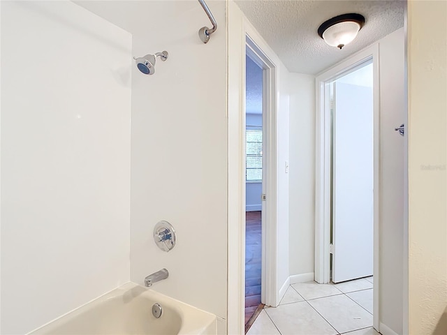 bathroom featuring tub / shower combination, tile patterned floors, and a textured ceiling