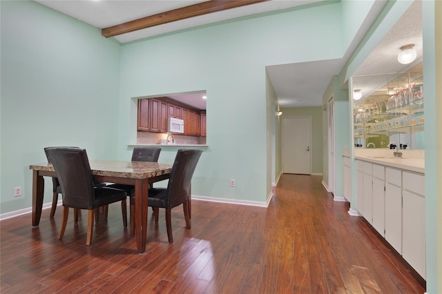 dining room with wood-type flooring and beam ceiling