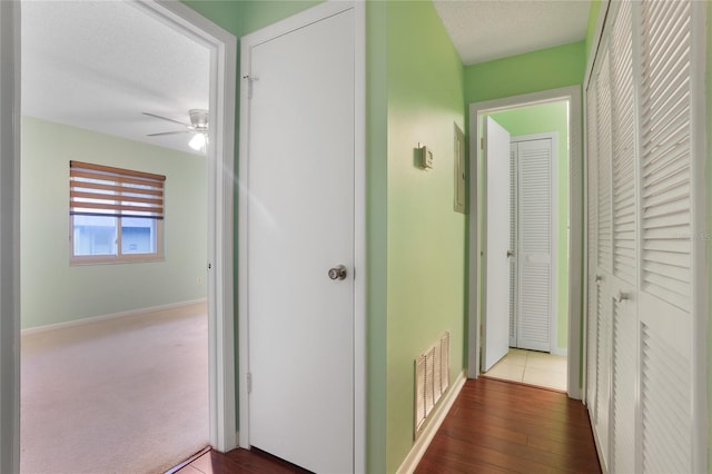 hallway featuring a textured ceiling and carpet flooring