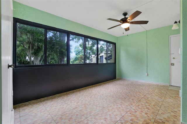 tiled spare room featuring ceiling fan