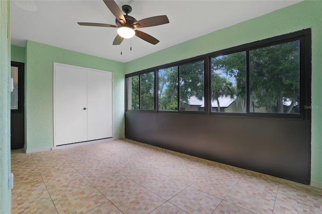 unfurnished bedroom featuring light tile patterned floors, ceiling fan, and a closet