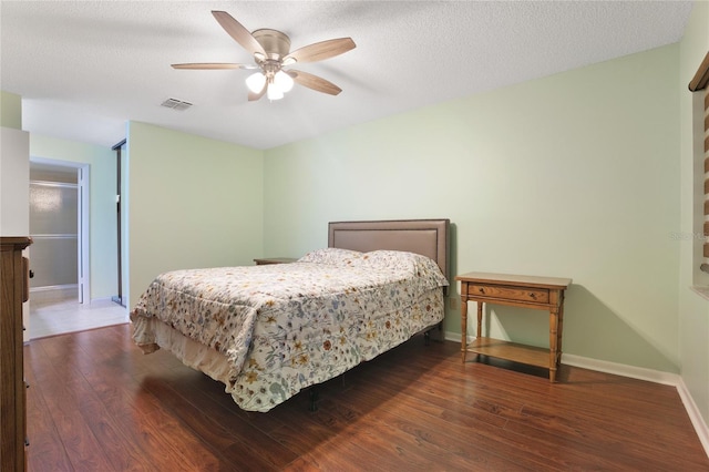 bedroom featuring dark wood-type flooring, a textured ceiling, and ceiling fan