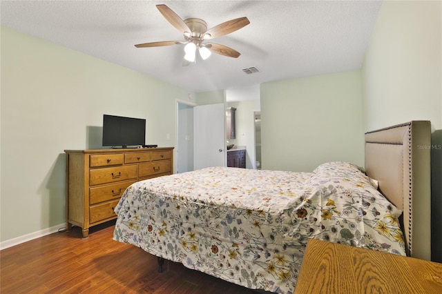 bedroom featuring ceiling fan, dark hardwood / wood-style floors, ensuite bathroom, and a textured ceiling