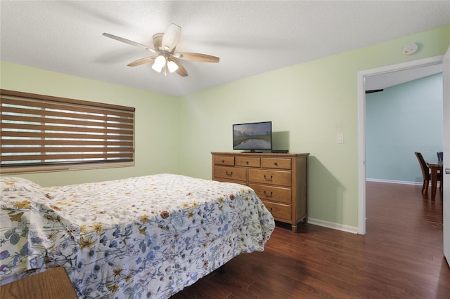 bedroom featuring a textured ceiling, ceiling fan, and dark hardwood / wood-style floors