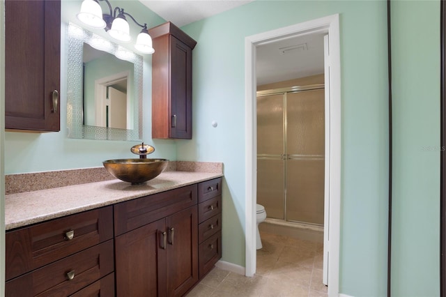 bathroom with tile patterned flooring, walk in shower, toilet, and vanity