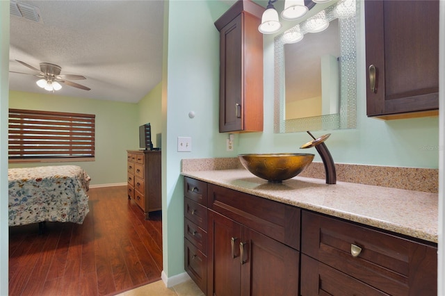 kitchen with a textured ceiling, hardwood / wood-style floors, sink, and ceiling fan