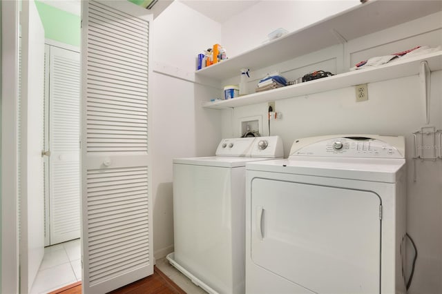 laundry area with washing machine and dryer and light tile patterned floors