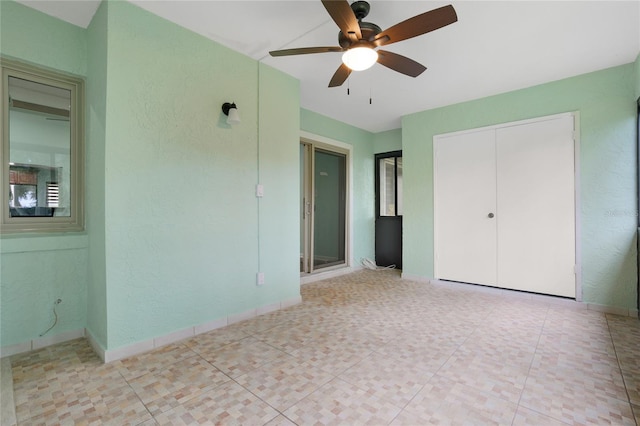 8 Escondido Cir Unit 78, Altamonte Springs, FL 32701 - unfurnished bedroom featuring a textured wall, a closet, baseboards, and a ceiling fan