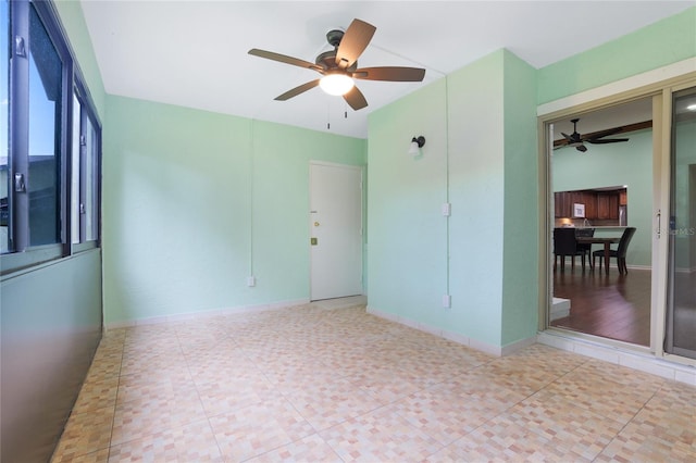 tiled spare room featuring ceiling fan