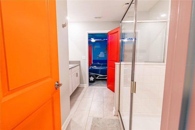 bathroom with tile patterned flooring, vanity, and a shower with door