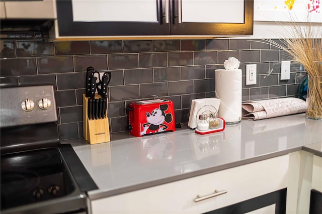 room details with decorative backsplash and black range with electric cooktop