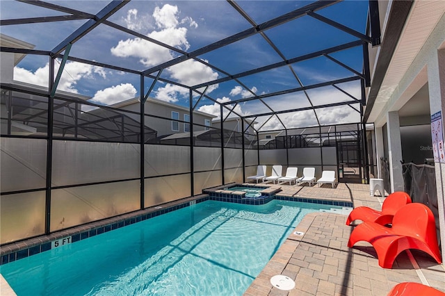 view of pool featuring glass enclosure, an in ground hot tub, and a patio area