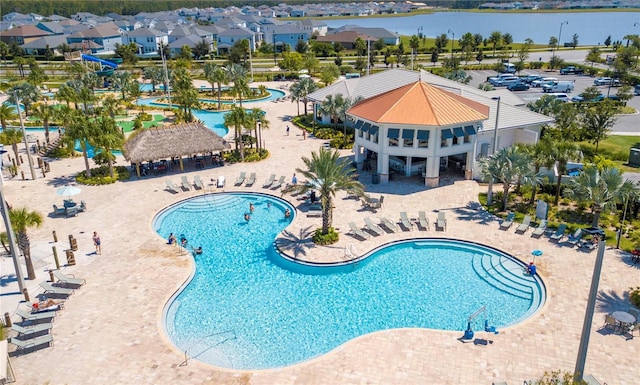 view of swimming pool with a water view and a patio area