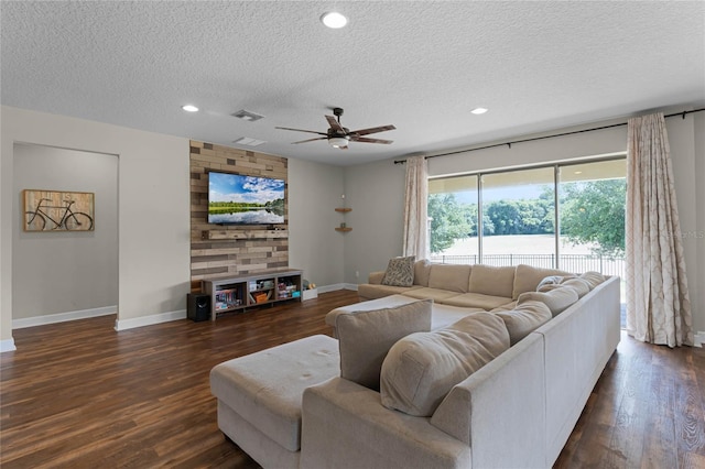 living room featuring ceiling fan, dark hardwood / wood-style flooring, and a textured ceiling