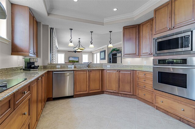 kitchen featuring pendant lighting, a raised ceiling, kitchen peninsula, stainless steel appliances, and crown molding