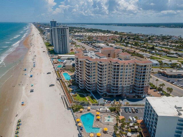 birds eye view of property with a water view and a beach view