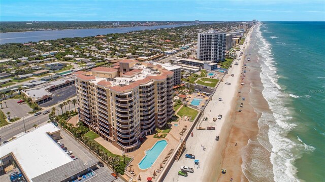 drone / aerial view featuring a beach view and a water view