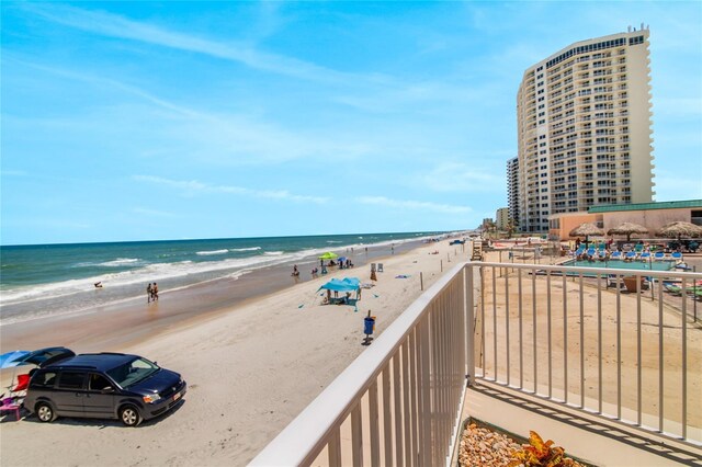 balcony featuring a water view and a beach view