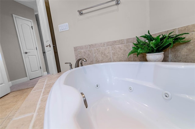 bathroom with tile patterned flooring and a tub