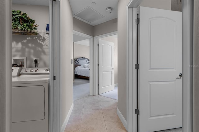 corridor featuring separate washer and dryer and light tile patterned floors