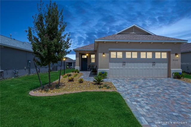 view of front of home with a garage and a lawn