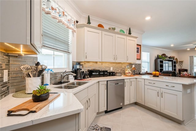 kitchen with kitchen peninsula, a wealth of natural light, sink, and stainless steel dishwasher