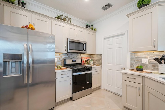 kitchen featuring white cabinets, decorative backsplash, ornamental molding, and appliances with stainless steel finishes