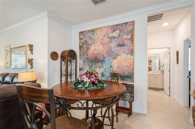 tiled dining room with a textured ceiling and ornamental molding