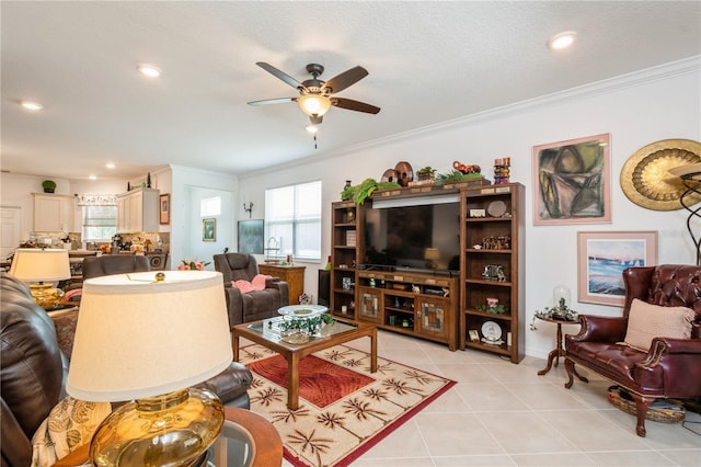 living room with ceiling fan, light tile patterned floors, a textured ceiling, and ornamental molding