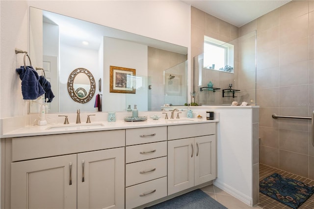 bathroom featuring tile patterned flooring, vanity, and tiled shower