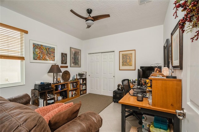 tiled office featuring ceiling fan and a textured ceiling